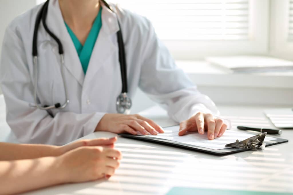 Board-certified plastic surgeon speaking with patient during consultation